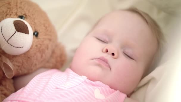 Liebenswertes Baby, das im Bett schläft. Porträt eines schlafenden Babys mit Spielzeugbär — Stockvideo