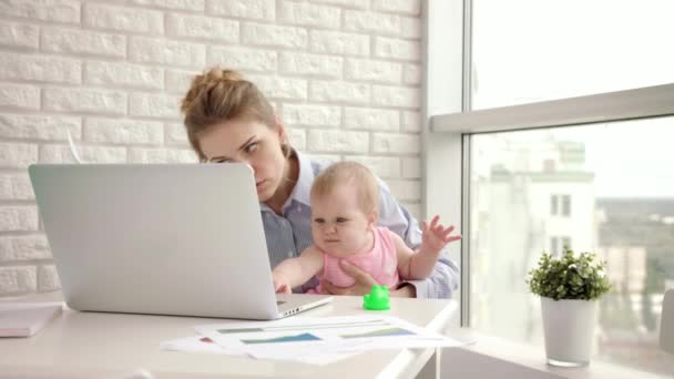 Mãe trabalhadora com bebê à mesa. Mãe de trabalho com belo bebê a mãos — Vídeo de Stock