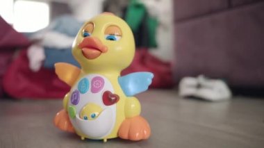 Oyuncak ördek yerde hareket ediyor. Düğmeli ve ışıkları hareket eden müzik oyuncağı