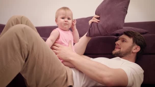 Babam kanepede bebekle oynuyor. Baba zamanı. Neşeli baba ve kız — Stok video