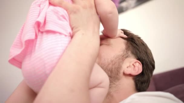 Отец целует дочь дома. Счастливого дня отца. Папа целует ребенка — стоковое видео