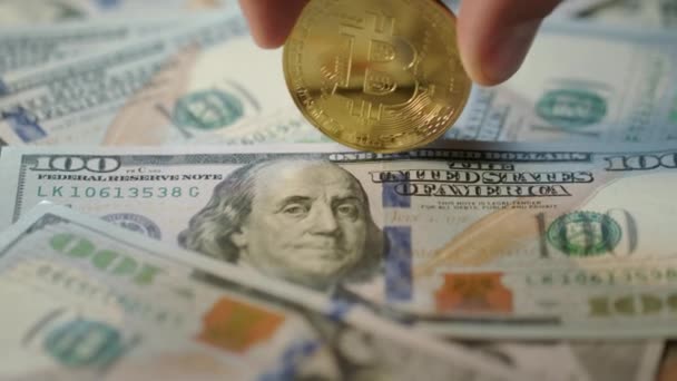 Bitcoin mining concept. Menselijke hand draaien gouden bit munt over dollar biljetten — Stockvideo