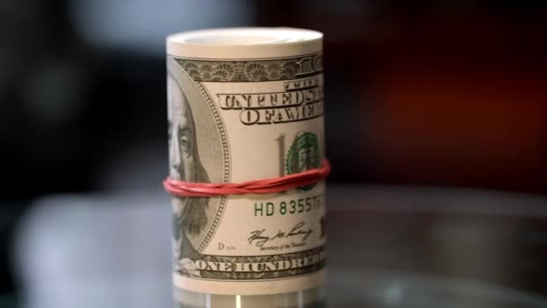 Roterande rulla av hundra dollarsedlar i Usa. Kontanta pengar rulla på tabell — Stockvideo