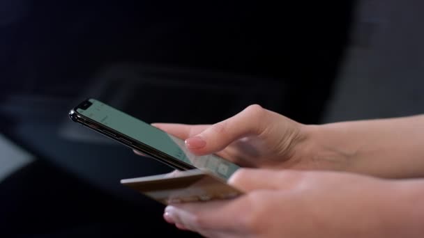 La mano femenina sostiene la tarjeta de crédito y el uso de smartphone para compras en línea — Vídeo de stock