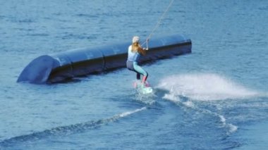 İnsanlar sahiptir gölde wakeboard sürme. Genç kadın su kayağı