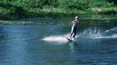 Güzel kız wakeboarding yaz Nehri üzerinde. Kadın pratik su kayağı