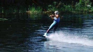 Su kayar gemide spor kadın. Wakeboarding göl kenarında okuyan kız