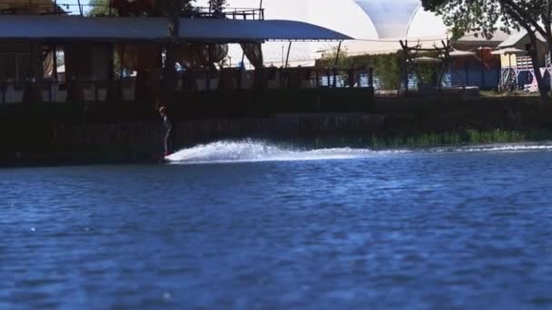 Entrenamiento deportivo wake boarding en la superficie acuática del moderno complejo de esquí acuático — Vídeos de Stock