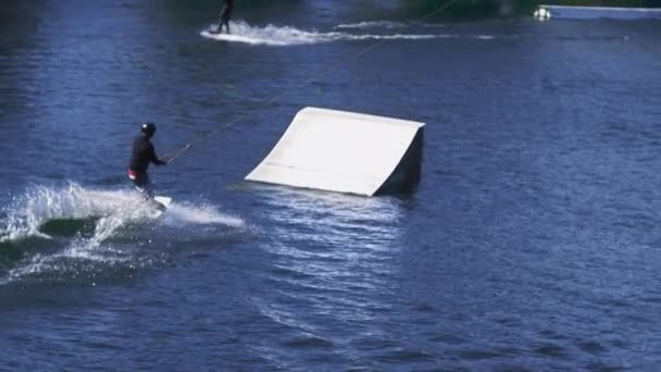 Esportista extrema treinando truques na água com trampolim — Vídeo de Stock