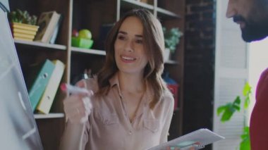 Gülümseyen iş kadın tartışırken iş planı planlama kurulu meslektaşı ile