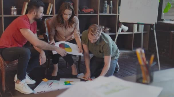 Радісна команда стартапів обговорює документи бізнес-плану в офісі — стокове відео