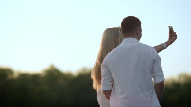 Ρομαντικό ζευγάρι λήψη φωτογραφιών στο ηλιοβασίλεμα. Γλυκιά στιγμή για το υπέροχο ζευγάρι — Αρχείο Βίντεο
