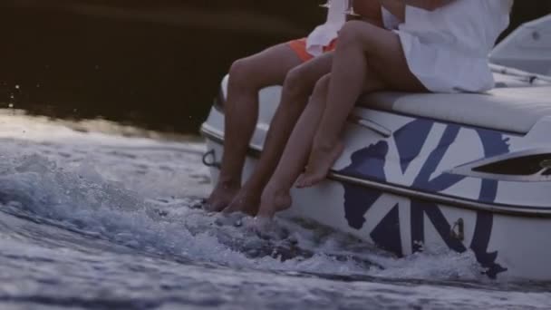 Gambe uomo e donna in flusso d'acqua schiumosa. Nautica su fiume in sera — Video Stock