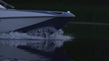 Hızlı motorlu tekne akşam nehirde yüzer. Yay kesme su tekne