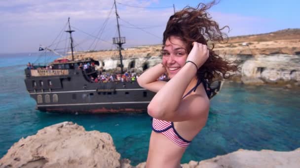 Retrato de una mujer feliz sonriendo en la orilla del mar. Mujer alegre buscando velero — Vídeos de Stock