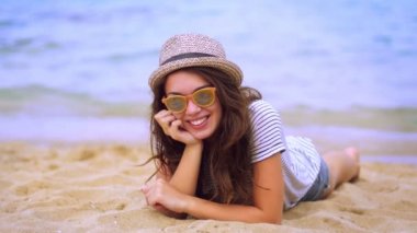 Şık kız güneş gözlüğü ve modern şapka tatil keyfi kum üzerinde döşeme