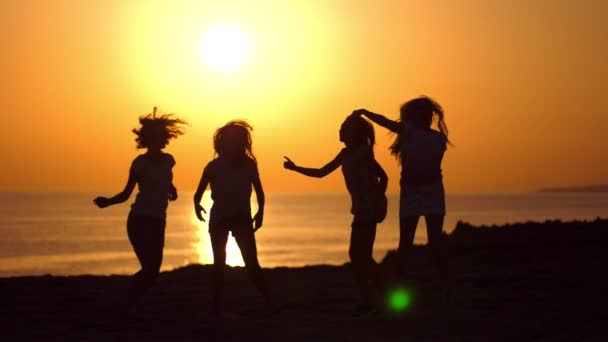 Dancing girls silhouettes at beach sunset. Beach party. Women silhouettes