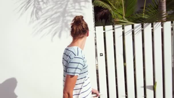 Jovem passeando ao longo da cidade resort tropical em câmera lenta — Vídeo de Stock