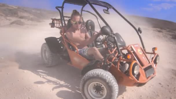 Driver man ride on sand buggy car in desert. Hipster man enjoy safari travel — Stock Video