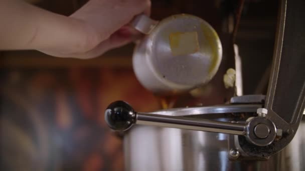 Arbeiter gießt Öl in Popcorn-Maschine. Vorbereitungen für Popcorn-Produktion — Stockvideo