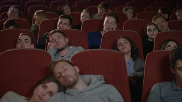 Gelangweiltes Publikum beim Filmgucken im Kino. Zuschauer schlafen nach langweiligem Film ein — Stockvideo