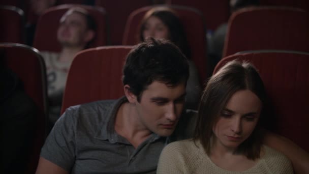 Girl making selfie on smartphone with boyfriend in movie theatre — Stock Video