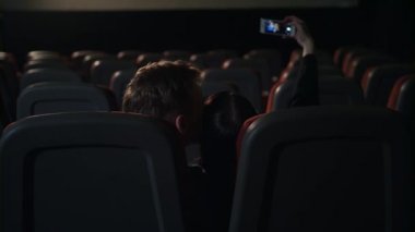 Boş sinema salonunda öpüşen genç insanlar. Aşk çift yapma selfie resmi