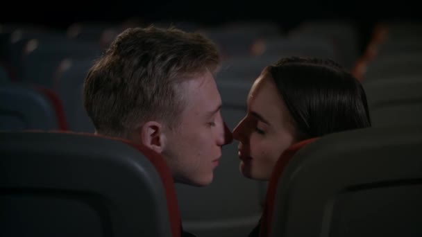 Joven chico y chica disfrutar de la pasión en el cine después de la película. Besar pareja — Vídeos de Stock
