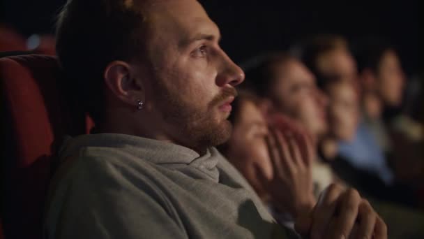 Jovem fica com medo enquanto assiste filme de terror. Filme assustador no cinema — Vídeo de Stock