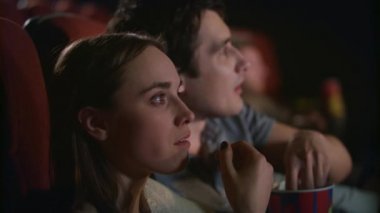 Genç çift film sinema keyfi. Kaç patlamış mısır yemek ve film izlerken