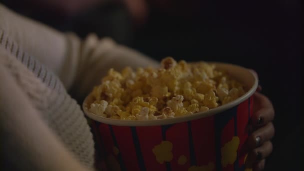 Női kéz vesz popcorn tárolót. Étkezési pop kukorica, mozi — Stock videók