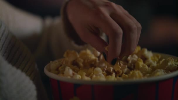 女性手采摘爆米花从纸桶特写。在电影院吃流行玉米 — 图库视频影像