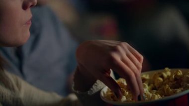 Patlamış mısır kağıt kova ağzına alarak kız. Pop corn sinemada yemek kadın