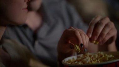 Kadın ve erkek el kağıt kova patlamış mısır almak. Sinemada pop mısır yemek