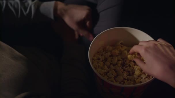 Ženské a mužské ruky vzít popcorn zrna z krabice popcornu v pomalém pohybu — Stock video