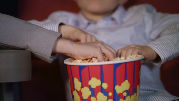 Mâinile copiilor iau popcorn din cutie de hârtie. Cinema alimente pentru copii — Videoclip de stoc