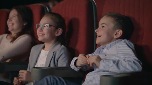 Children watching movie enthusiastically in cinema. Child entertainment concept — Stock Video
