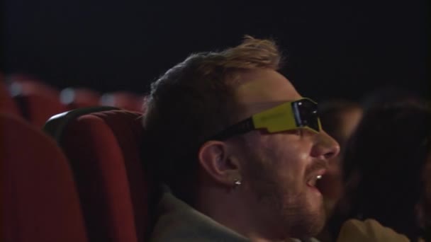 男は、スローモーションで映画館で映画メガネを外してください。3 d 映画から疲れてください。 — ストック動画