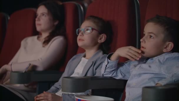 Kids are frightened at movie theatre. Scared children cover faces by hands. — Stock Video
