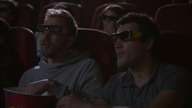 Man 3d Sinemada patlamış mısır yemek. Spectactors sinema atıştırmalıkların tadını çıkarın.