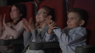 Sinemada applauding memnun çocuk. Fırtına sinemada alkış