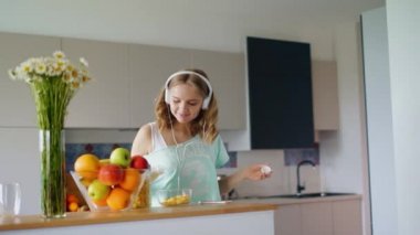 Müzik dinleme ve mutfakta eğlenerek güzel kız. Mutlu kadın yemek