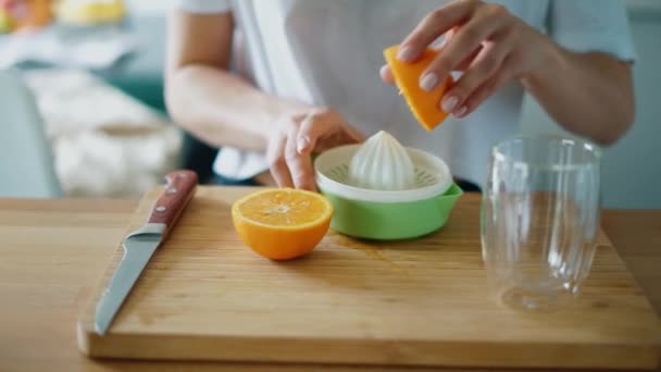Mujer manos exprimiendo jugo de naranja fresco con exprimidor de cítricos — Vídeo de stock