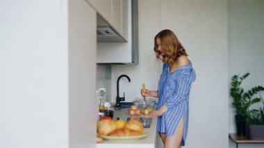 Şehvetli kadın omlet yemek pişirmek için cam kasede yumurta çırpma. Kahvaltı yumurta