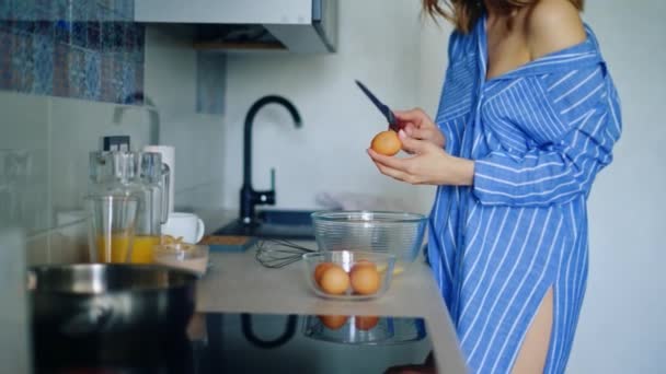 Сексуальная девушка в сонной одежде готовит традиционный завтрак с яйцами — стоковое видео