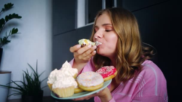 Comer mujer disfrutar de cupcake crema. Mujer degustación galletas dulces — Vídeos de Stock