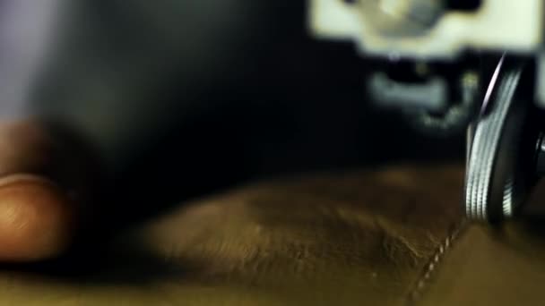 Leatherworker termine la couture de pièces en cuir. Fermer les mains de l'homme travaillant 