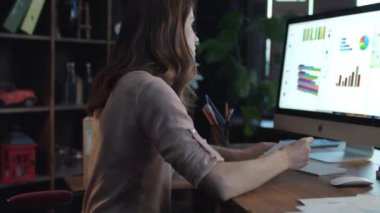 Genç kadın iş analisti mali rapor oluşturmak için bilgisayar kullanma