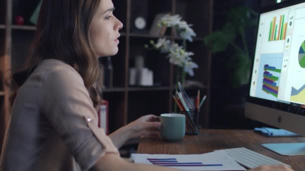 Pensando mujer de negocios bebiendo té de la taza y mirando la pantalla de la computadora — Vídeos de Stock