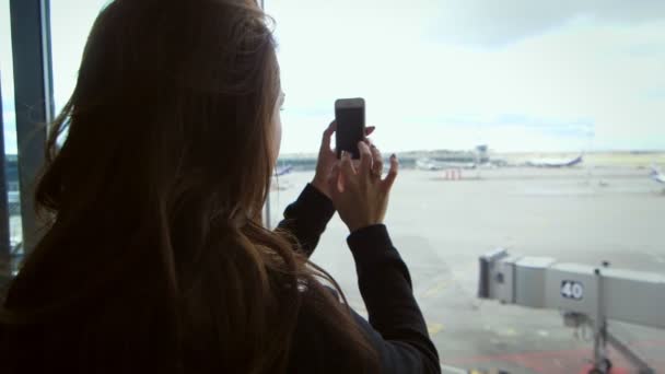 若い女性は彼女のスマート フォンでビデオを作るします。メモリ用フィルム — ストック動画